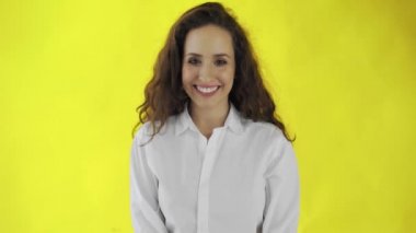 Stüdyoda gülümseyen kız portresi. Sarı arka planda gülümseyen neşeli bir kadın. Doğal kadın güzelliği.