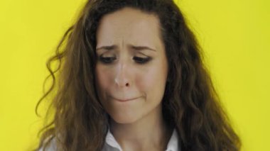 Sarı arka planda genç esmer kadın portresi. Genç kız hayal kırıklığına uğradı