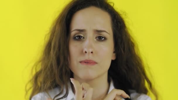 Triste pensativo jovem bela mulher na camisa de pé no estúdio com fundo amarelo . — Vídeo de Stock