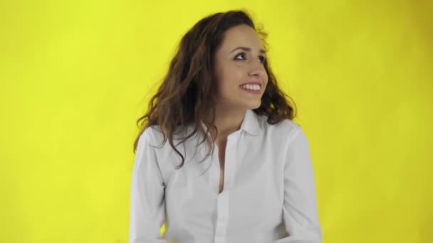 아름다운 여성의 초상화가 완벽 한 매력적 인 미소로 웃고 있습니다. 스튜디오의 노란색 배경 위 에서. — 비디오