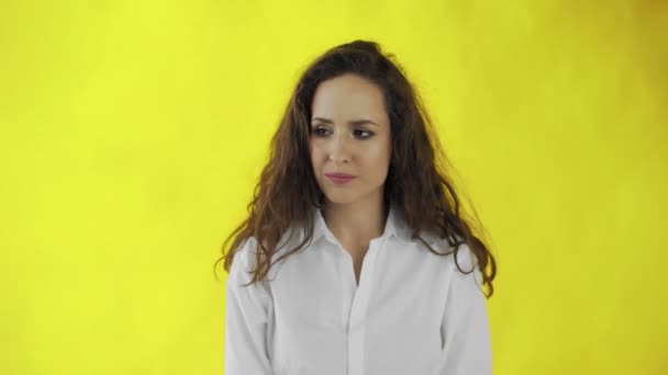 Portrait of serious young woman shaking head and expressing denial, isolated over yellow background — Stock Video