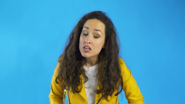 Een zeer boze en gefrustreerde vrouw in Studio met blauwe achtergrond. — Stockvideo