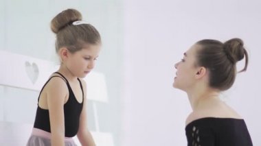 Şirin bayan bale öğretmeni üzgün öğrencisine oyuncak veriyor.