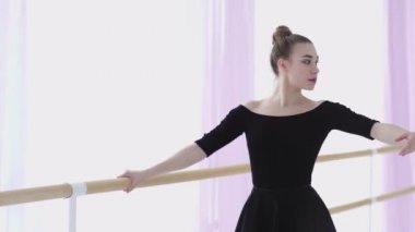 Profesyonel balerin, bir bale barının yanında pratik yapıyor.