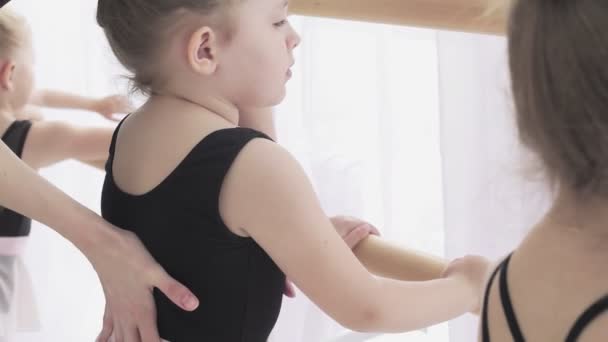 Dançarina na escola de balé aprende a dançar. Pequena bailarina em treinamento em terno de dança preta . — Vídeo de Stock