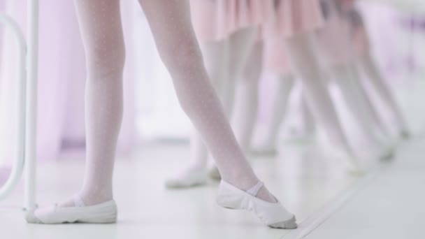 Cerca de los pies de niñas irreconocibles en calcetines blancos y zapatos de ballet, su profesor de ballet corrigiéndolos — Vídeo de stock