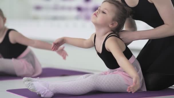 Holčička cvičí protahování v moderní baletní škole. Talentované děti. Moderní cool baletní studia interiér na pozadí.