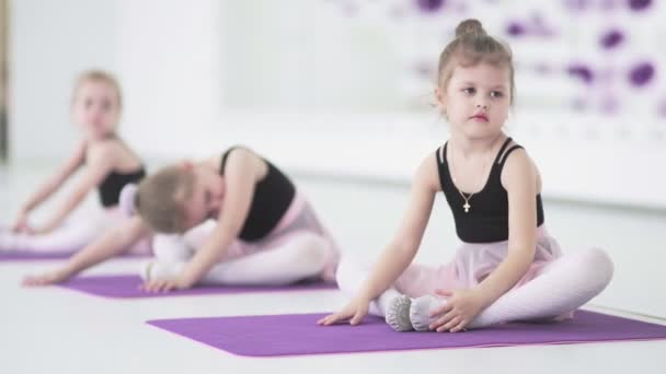 Kleine Mädchen dehnen sich und machen Übungen in der Ballettschule — Stockvideo