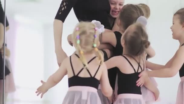 Linda profesora de ballet y sus pequeños estudiantes se están abrazando — Vídeos de Stock