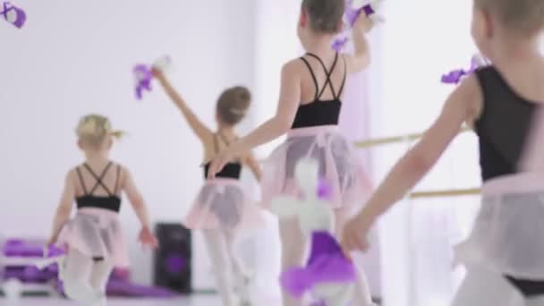 Κοριτσάκια με παιχνίδια στα χέρια τρέχουν στην αίθουσα μπαλέτου. — Αρχείο Βίντεο