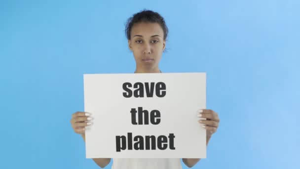 Афро-американская девушка-активистка с плакатом "Спасите планету" на синем фоне — стоковое видео