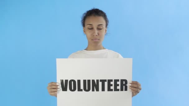 Afro-American Girl Activist With Volunteer Poster showing thumb up on blue background — Stock Video