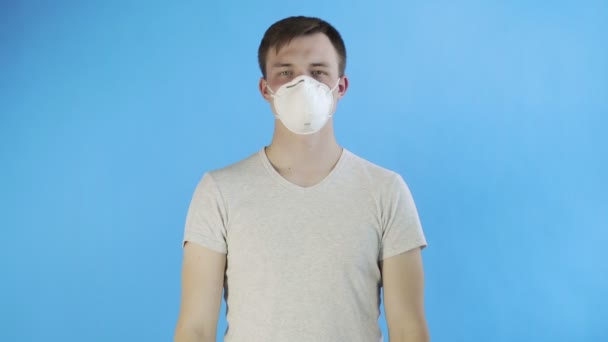 Молодой человек-активист с маской на лице и с постером Think Planet на синем фоне — стоковое видео