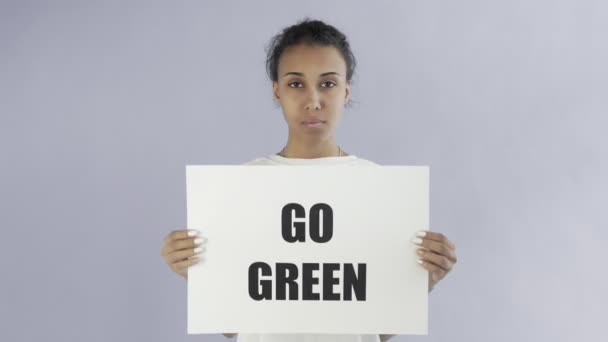 Афроамериканская девушка-активистка с плакатом "Спаси планету" на сером фоне — стоковое видео