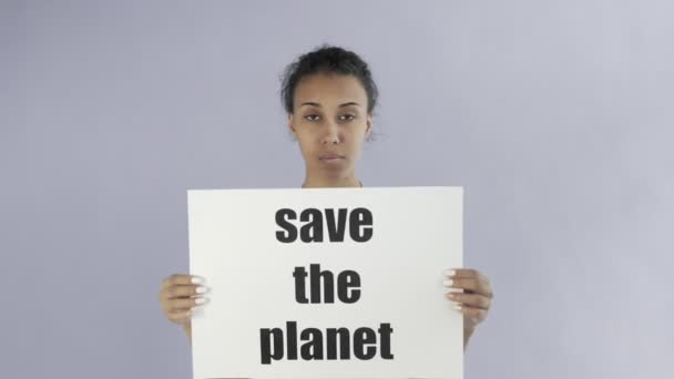Афроамериканская девушка-активистка с плакатом "Спаси планету" на сером фоне — стоковое видео