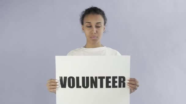 Afro-americká dívka aktivista s dobrovolník plakát ukazující palec nahoru na šedém pozadí — Stock video