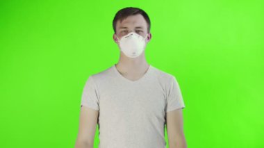 Yüzünde maske ve krom anahtar arka planında yardım posteri olan genç bir eylemci.