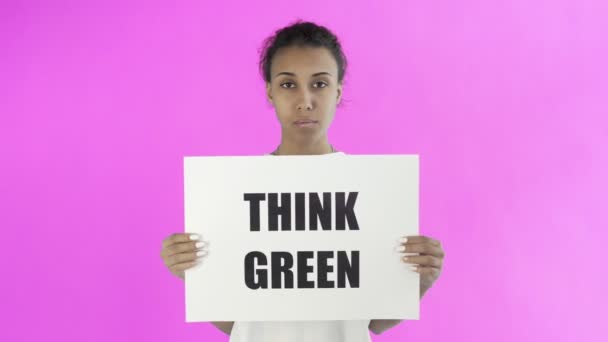 Activista afroamericana con afiche Think Green sobre fondo rosa — Vídeos de Stock