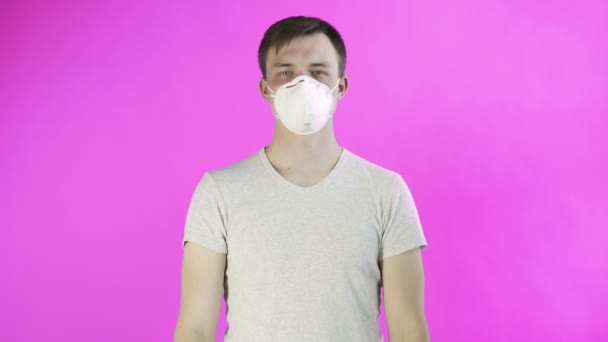 Молодой человек-активист с маской на лице и с постером Think Planet на розовом фоне — стоковое видео