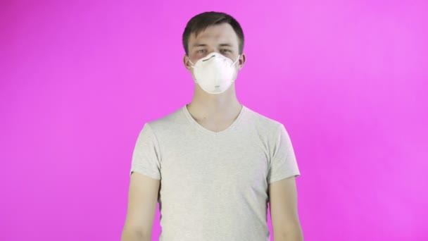 Mladý muž aktivista s maskou na obličeji a s plakátem HELP na růžovém pozadí — Stock video