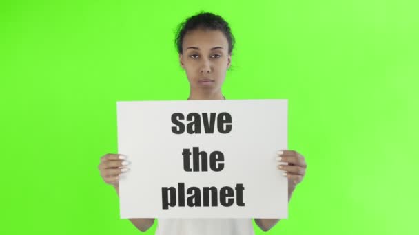 Афро-американская девушка-активистка с плакатом "Спасите планету" на фоне хромы — стоковое видео