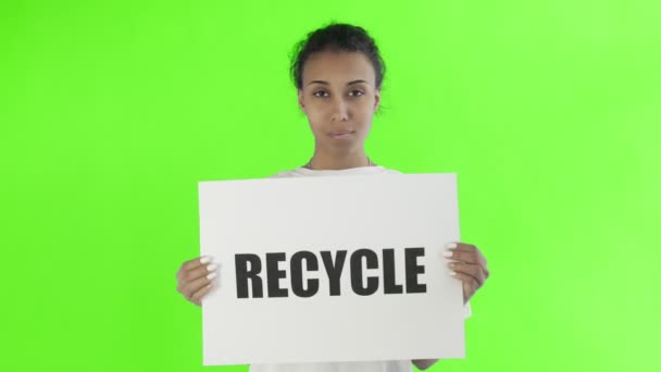 Афроамериканская девушка-активистка с плакатом "Recycle" показывает большой палец на фоне хроматического ключа — стоковое видео