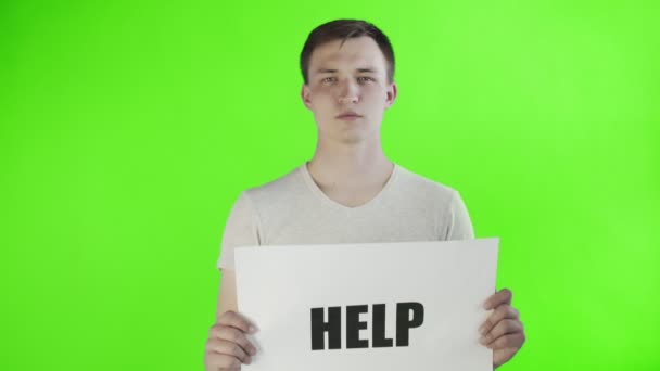 クロマキーの背景にヘルプポスターを持つ若い男の活動家 — ストック動画