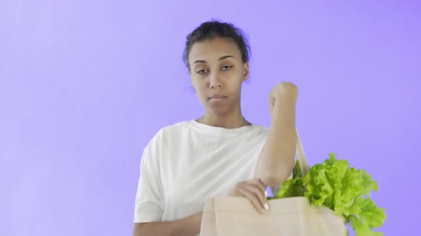 Афро-американская девушка-активистка с пластиковыми и стеклянными чашками на фиолетовом фоне — стоковое видео