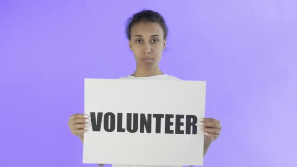 Афроамериканская девушка-активистка с плакатом волонтера на фоне Вайолет — стоковое видео