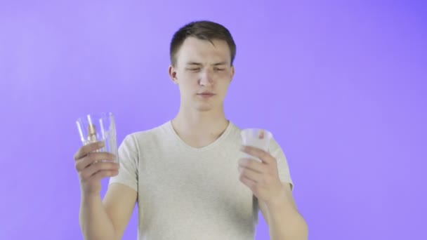 若い男の活動家ともにプラスチックとガラスカップ上のバイオレット背景 — ストック動画