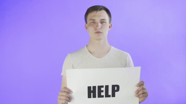 Junger Mann Aktivist mit HELP-Poster auf violettem Hintergrund — Stockvideo
