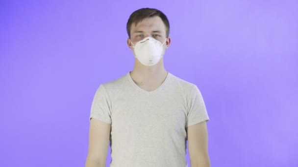 Junger Mann Aktivist mit Maske im Gesicht und Think Planet Poster auf violettem Hintergrund — Stockvideo