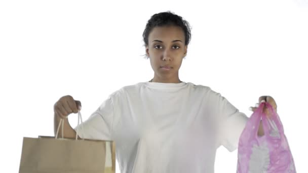 Afro-americano menina ativista fazendo uma escolha entre papel e saco de plástico no fundo branco — Vídeo de Stock