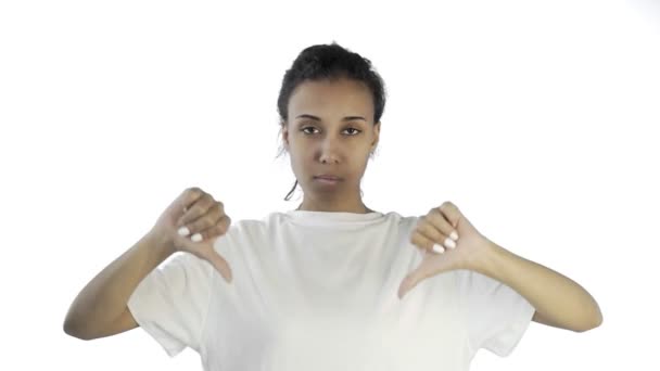 Hermosa joven con una camiseta blanca muestra el pulgar hacia abajo con ambas manos sobre fondo blanco — Vídeos de Stock