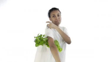 Beyaz arka planda sebzeli çanta taşıyan kadın.