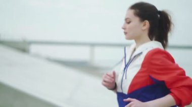 Merdivenlerden koşarak çıkan sağlıklı genç bir kadın. Dişi sporcu merdivenlerden tırmanıyor..