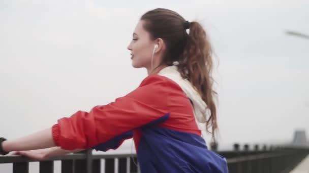 Женщина в наушниках делает отжимания во время кросса на свежем воздухе — стоковое видео