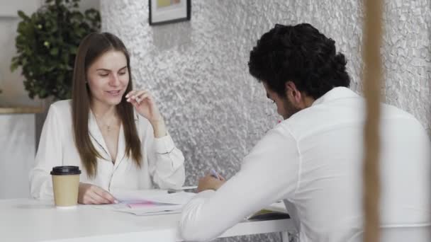 Junge Geschäftsleute unterhalten sich im Loft Office. Charmante Frau spricht mit Mann und lacht — Stockvideo