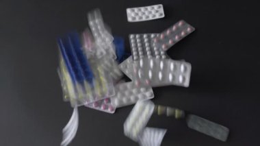 Farklı ilaç hapları siyah kata düşüyor.