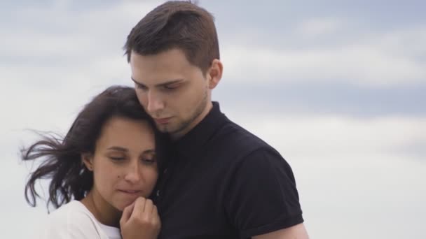 Romantisches junges Paar umarmt sich im Park am Himmel im Hintergrund. — Stockvideo