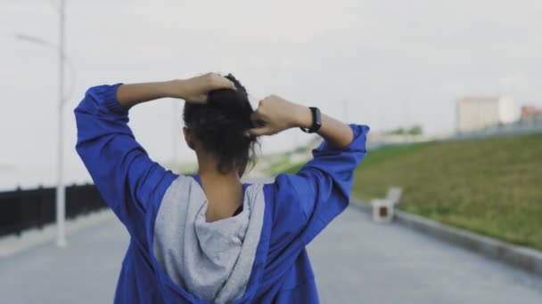 Corredor femenino preparándose para correr y atándose el pelo — Vídeos de Stock