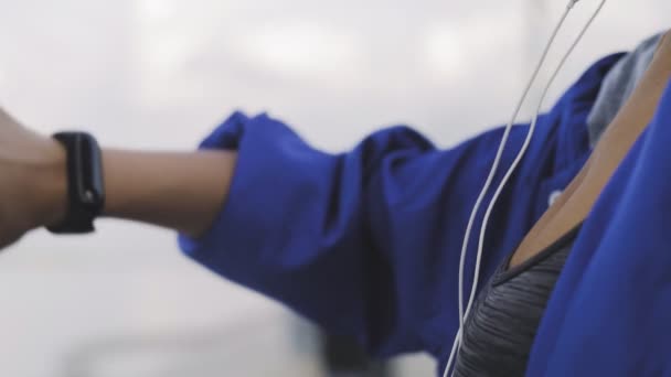 Mujer corredor afroamericano con auriculares usando pulsera de fitness antes de correr — Vídeos de Stock