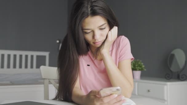 Young beautiful woman using phone while at home. — Stock Video