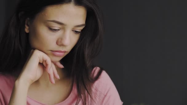 Chica sentada en el escritorio escribe texto en un cuaderno — Vídeo de stock