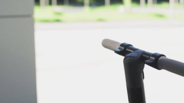 Genç bir kadın elektrikli scooter 'ı çalıştırıp uzaklaşır.