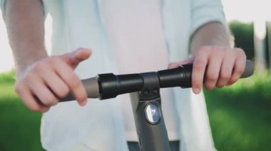 Erkek ellerine yakın çekim ve elektrikli scooter.