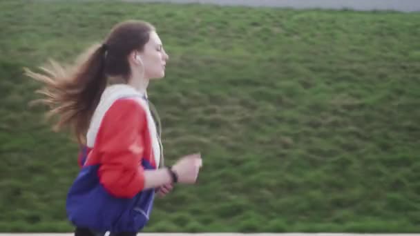 屋外フィットネストラッカーのウェアラブル技術を行使公園で実行しているランナー女性 — ストック動画