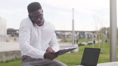 Afro-Amerikalı adam şehir parkında lezzetli bir öğle yemeği yiyor.