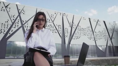 Kadın sekreter patronla akıllı telefondan konuşuyor ve belgelerimizi kontrol ediyor.