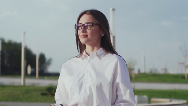 Mujer de negocios sonriente caminando en el parque de la ciudad . — Vídeo de stock